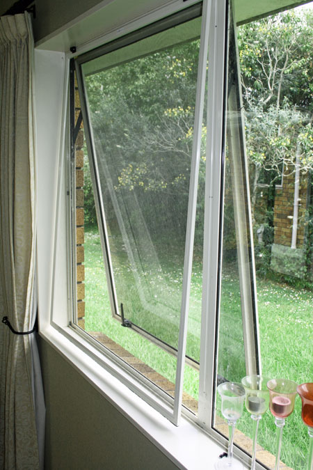 Close up of hinged window screen from inside the screen from theside and slightly open